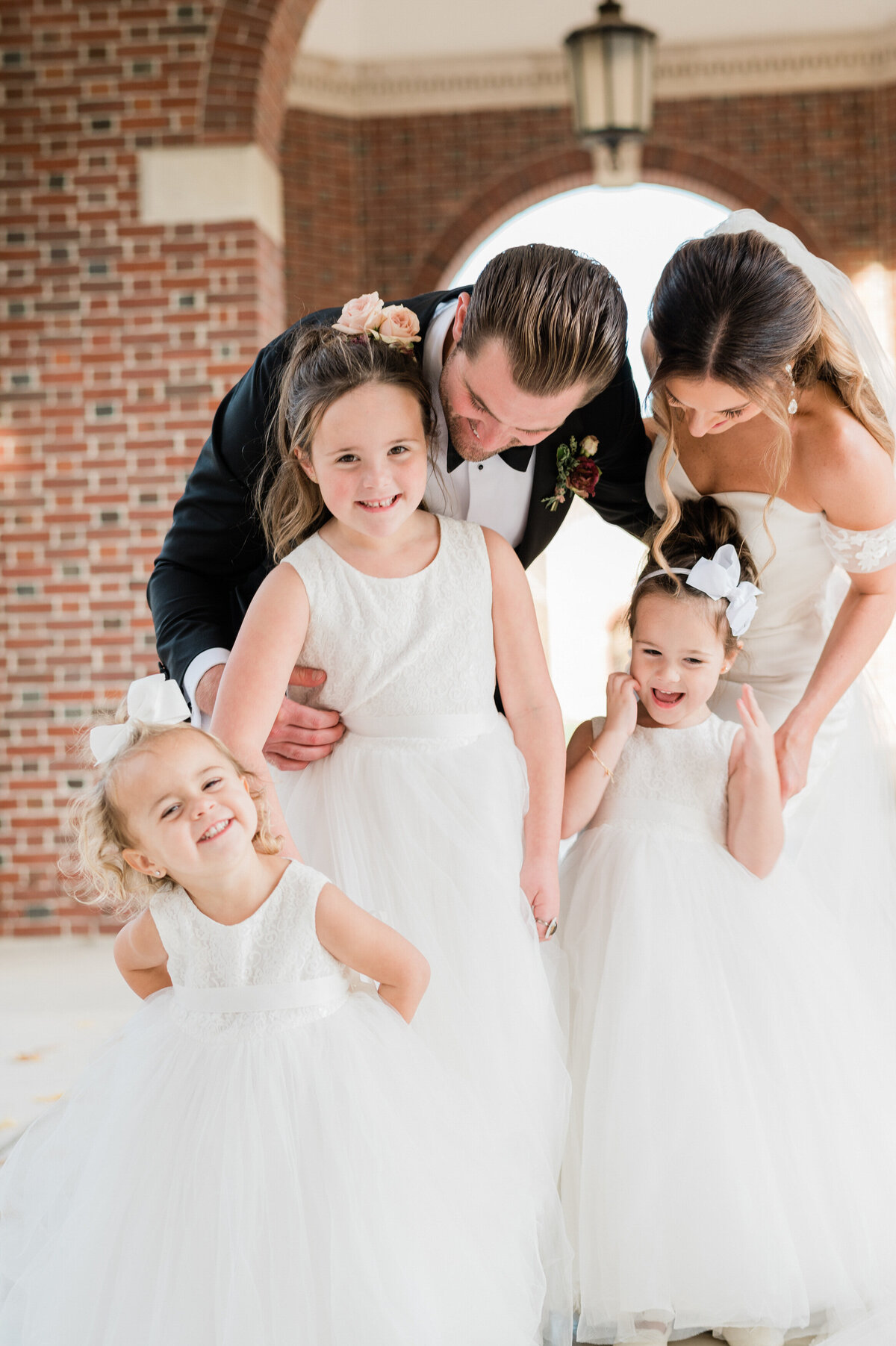 Bride and groom pose with two flower girls 