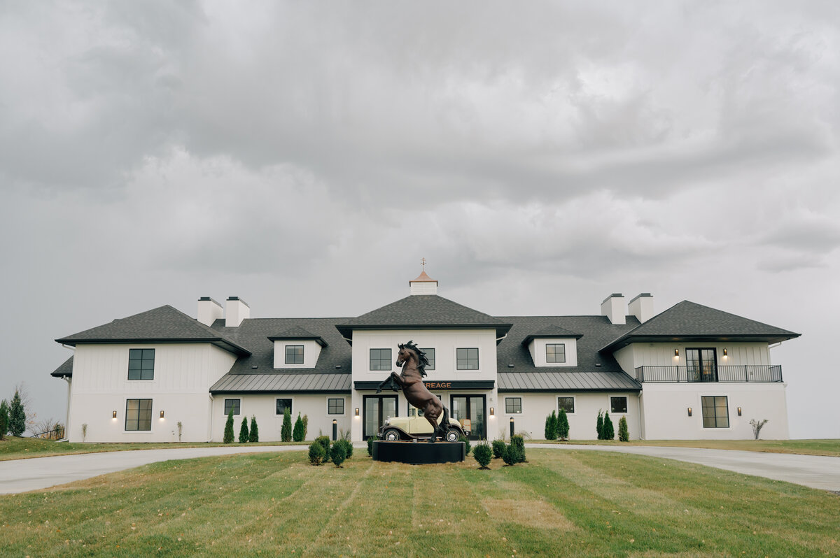 Lincolne NE Wedding Venue called The Acreage that is White and black wedding venue with an iron horse in front . Photo by Anna Brace Photography, a lincoln wedding photographer.