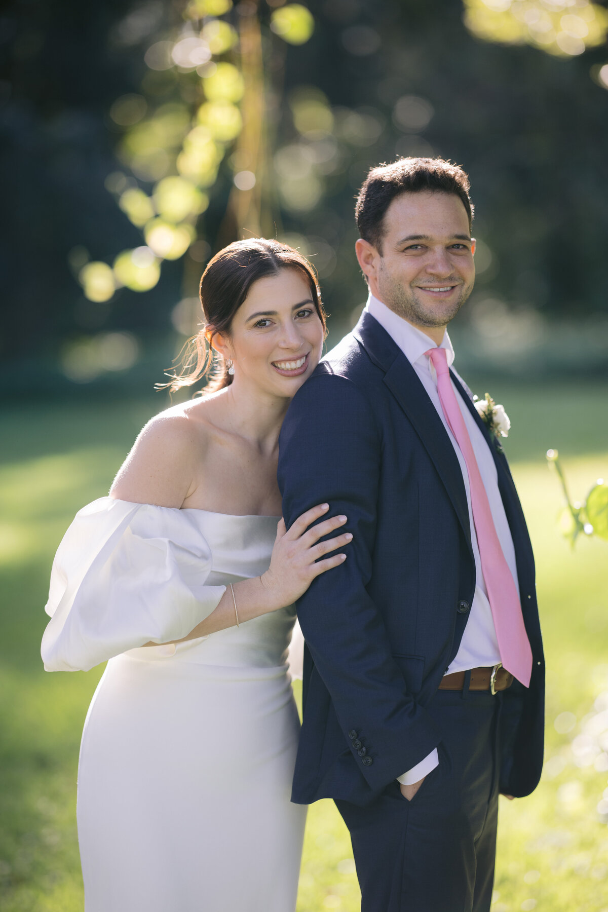 Bride and groom happily posing outdoors with natural greenery in the background, Miami, Florida.