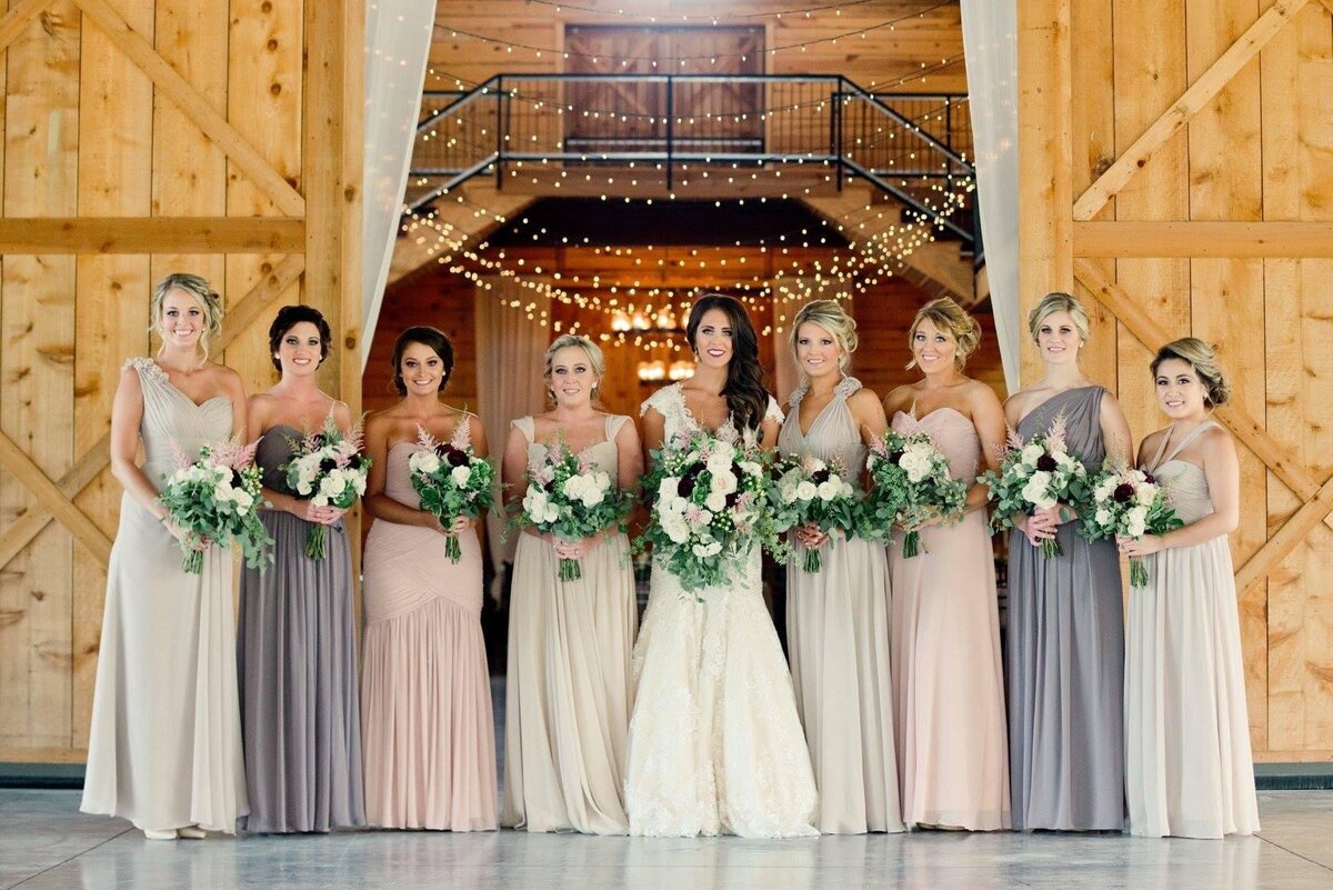 Bride and her bridesmaids in front of wedding barn
