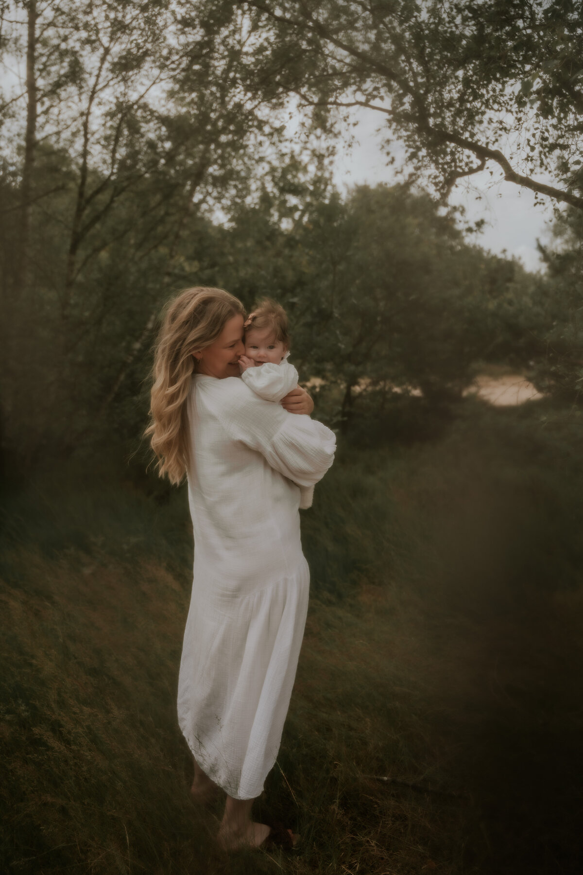 Mama houdt dochter vast in grasveld tijdens familie fotoshoot in Antwerpen