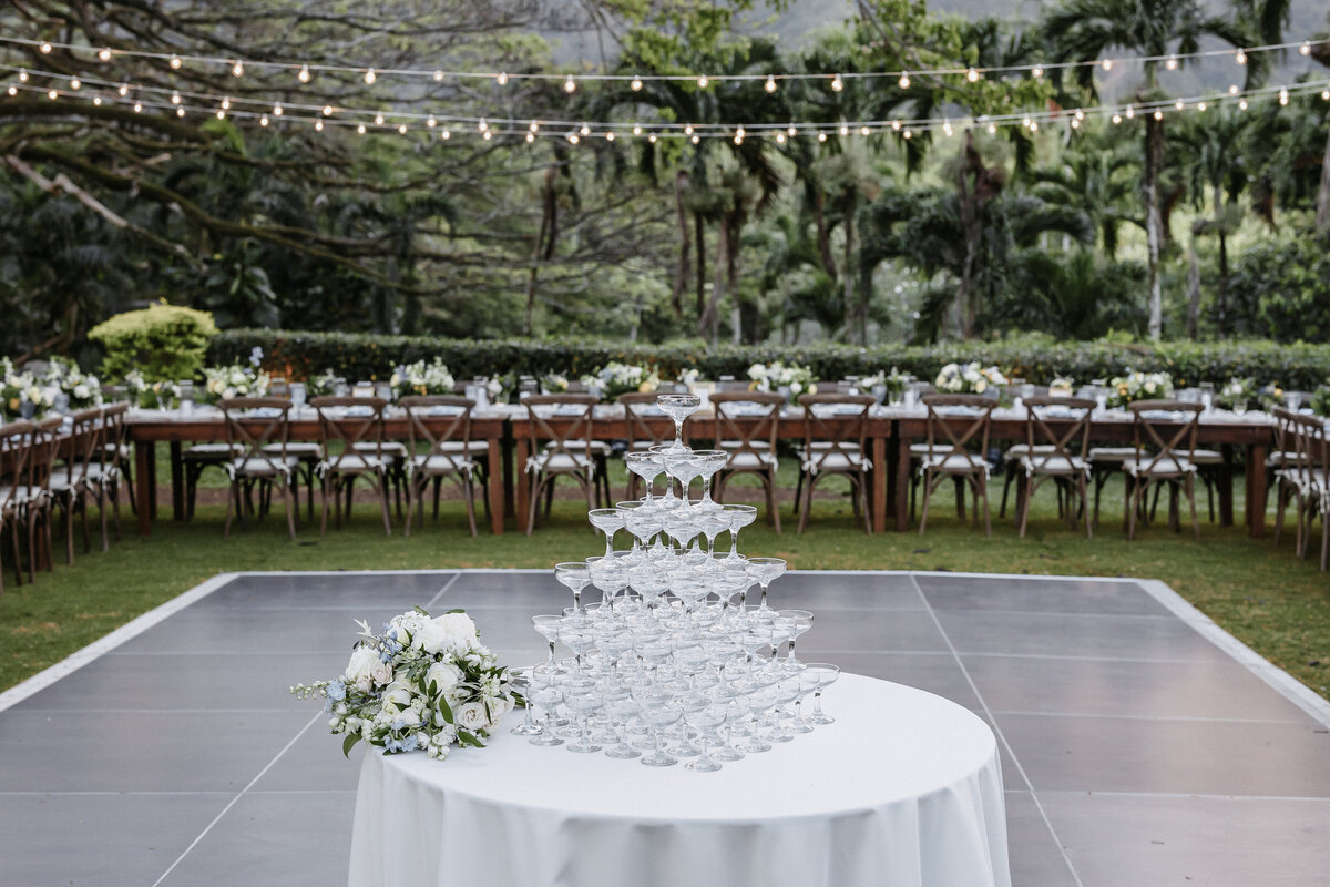 Champagne tower on ivory round tablecloth in front of dance floor and long U shaped tables