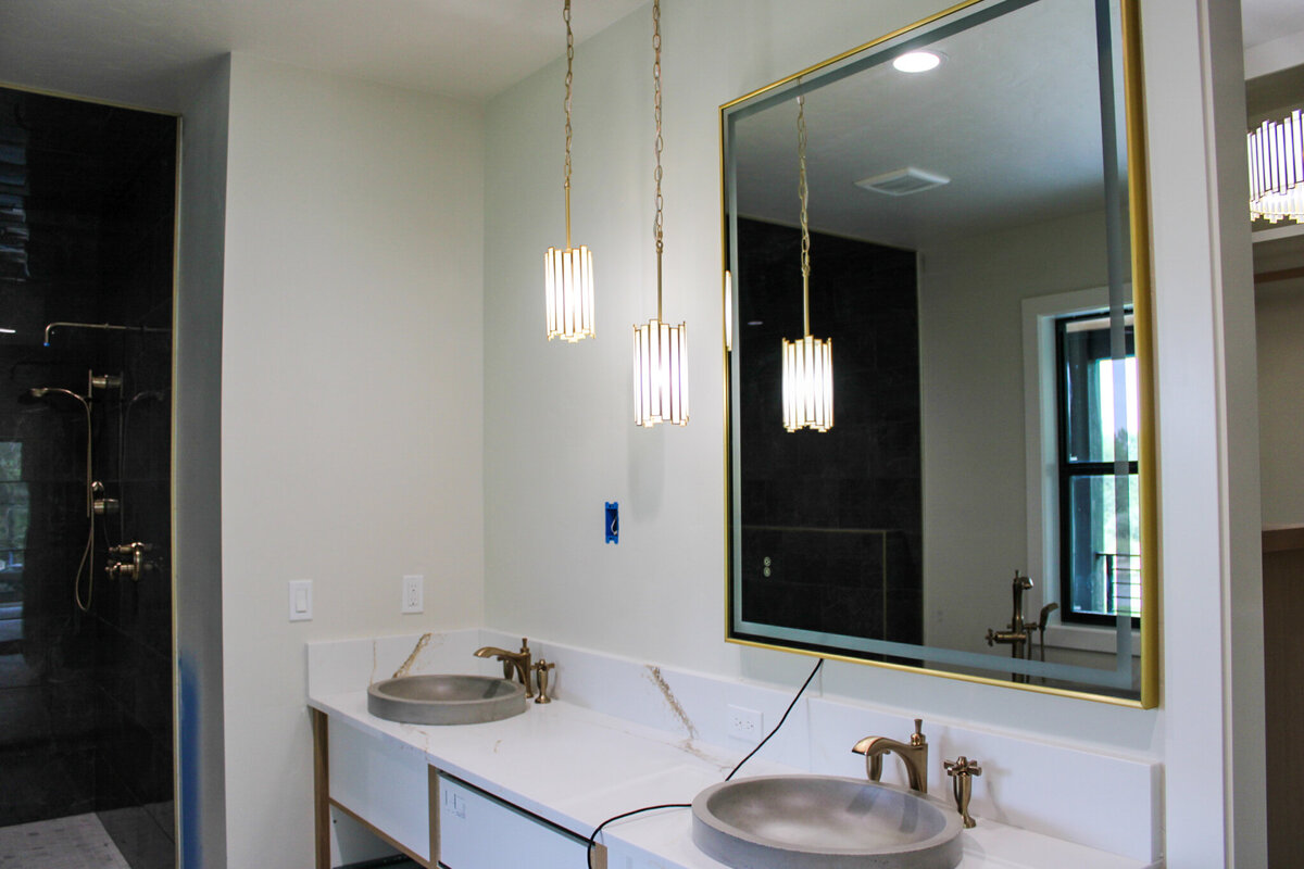 modern bathroom with his and hers sinks with elegant lighting fixtures