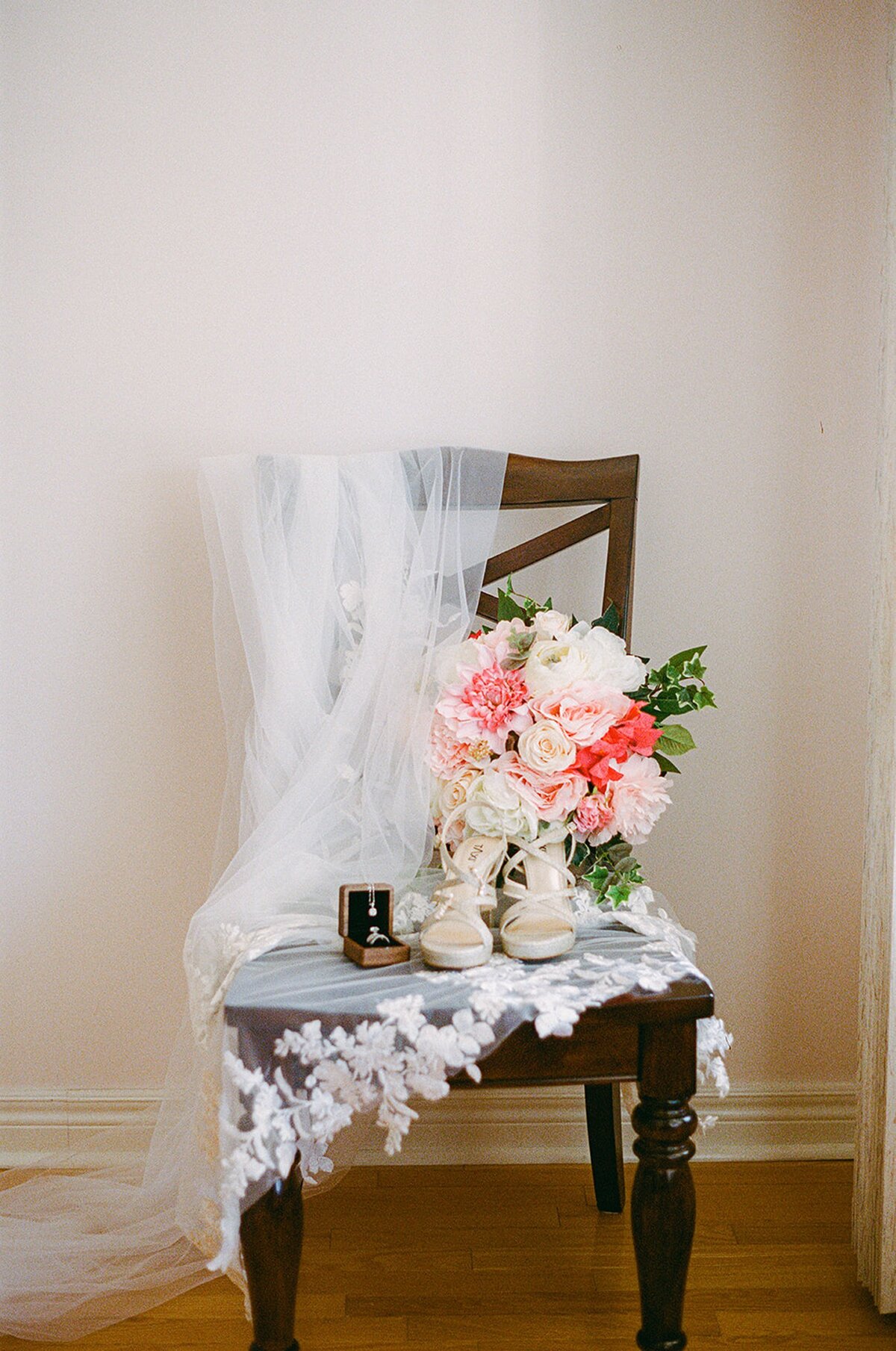 Wedding veil and pink bouquet on chair
