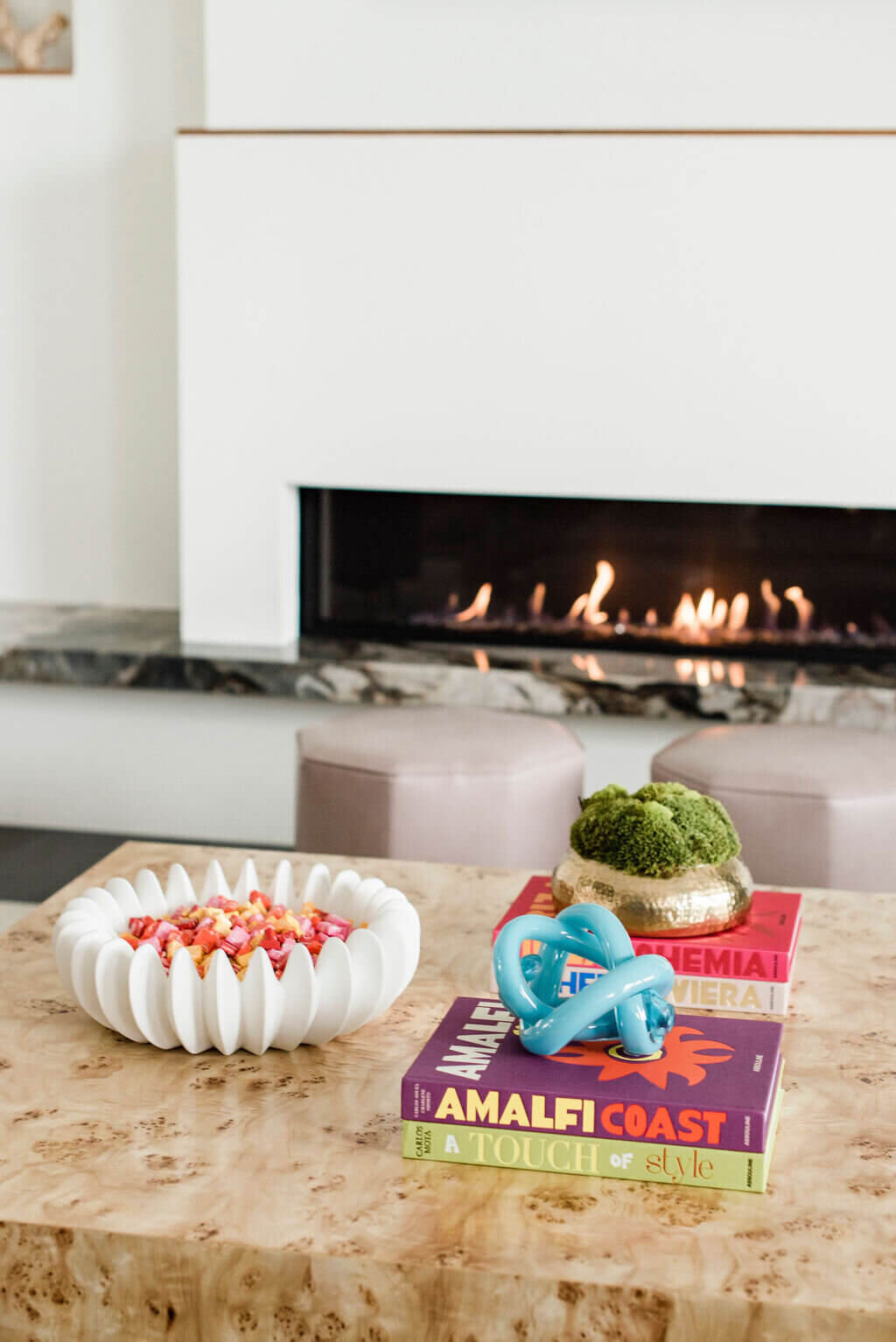 wooden coffee table with blue sculpture next to a fireplace