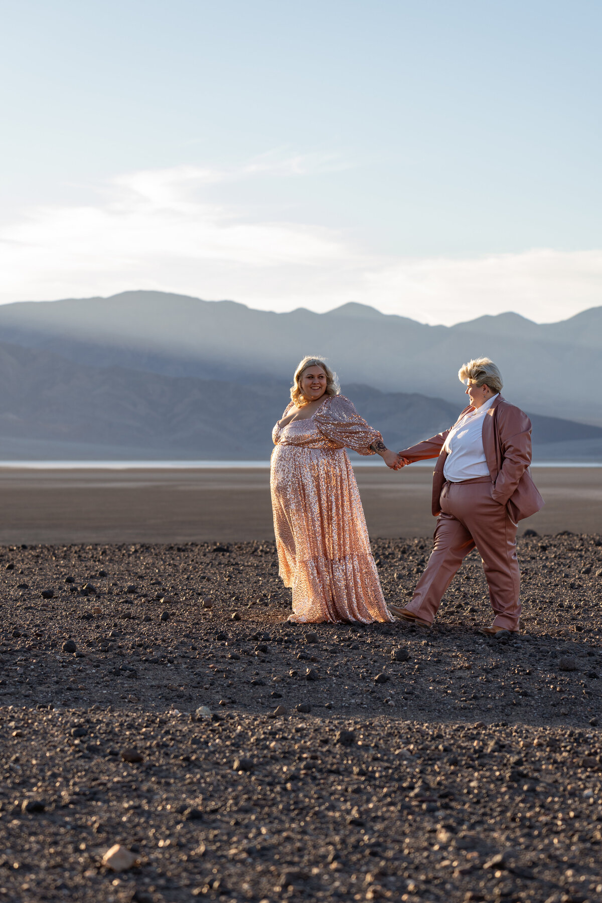 A couple with their arms out holding each other's hands