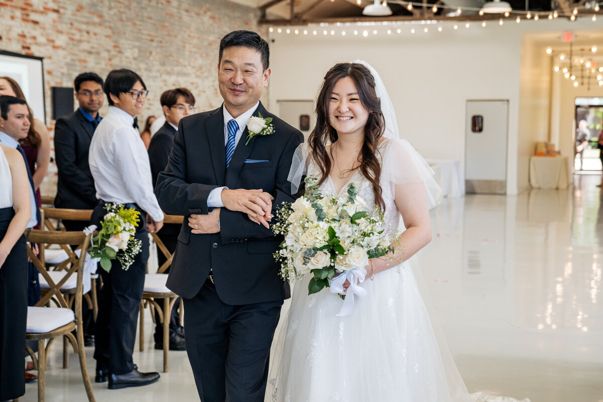 bride smiling with her father walking down the aisle at Graham Mill wedding