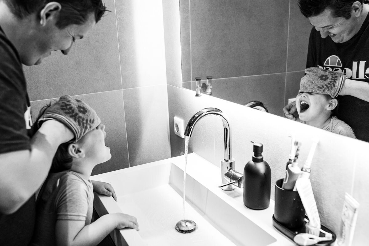 gezinsfoto thuis vader wast gezicht lachende zoon