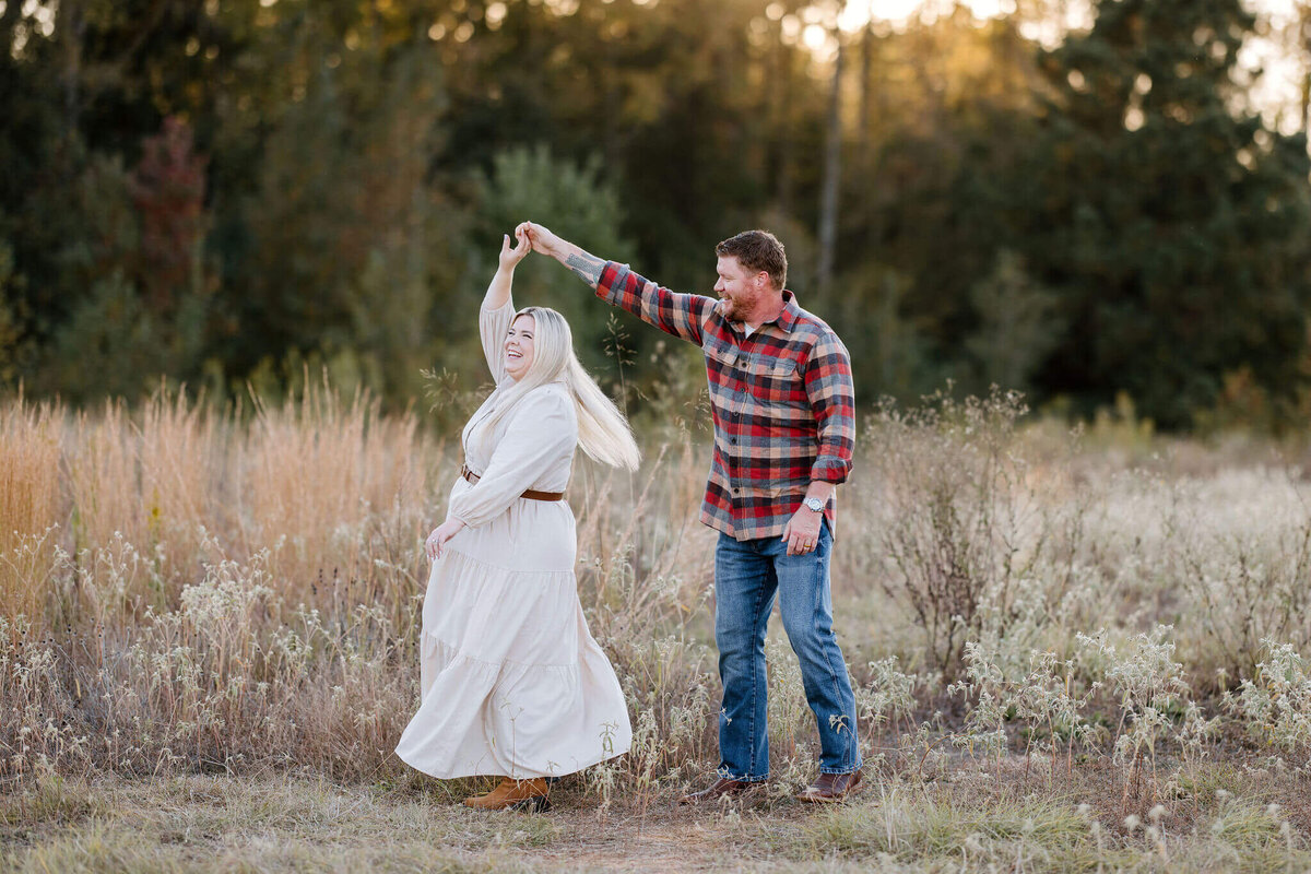 husband dancing with wife wearing neutral colors during Longview, TX family photoshoot
