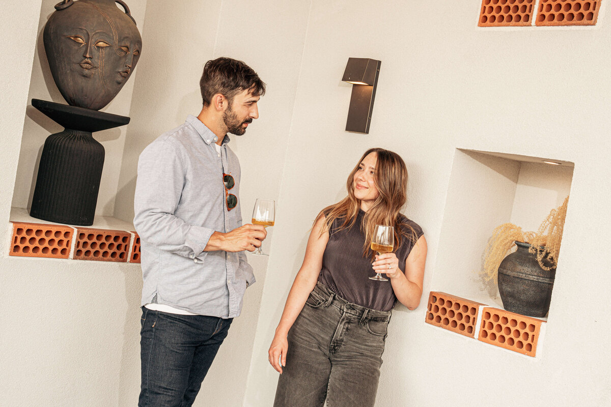Two people enjoying wine together on the rooftop bar of Visuals in Asheville, NC