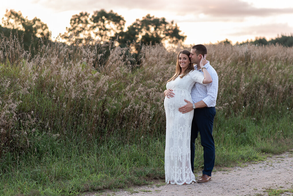 Couple embracing at maternity session in field at sunset | Sharon Leger Photography | CT Newborn & Family Photographer | Canton, Connecticut