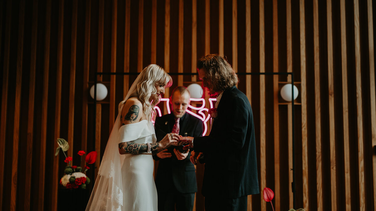 A bride and groom exchange rings at their wedding at Ducie Street Warehouse in Manchester. 