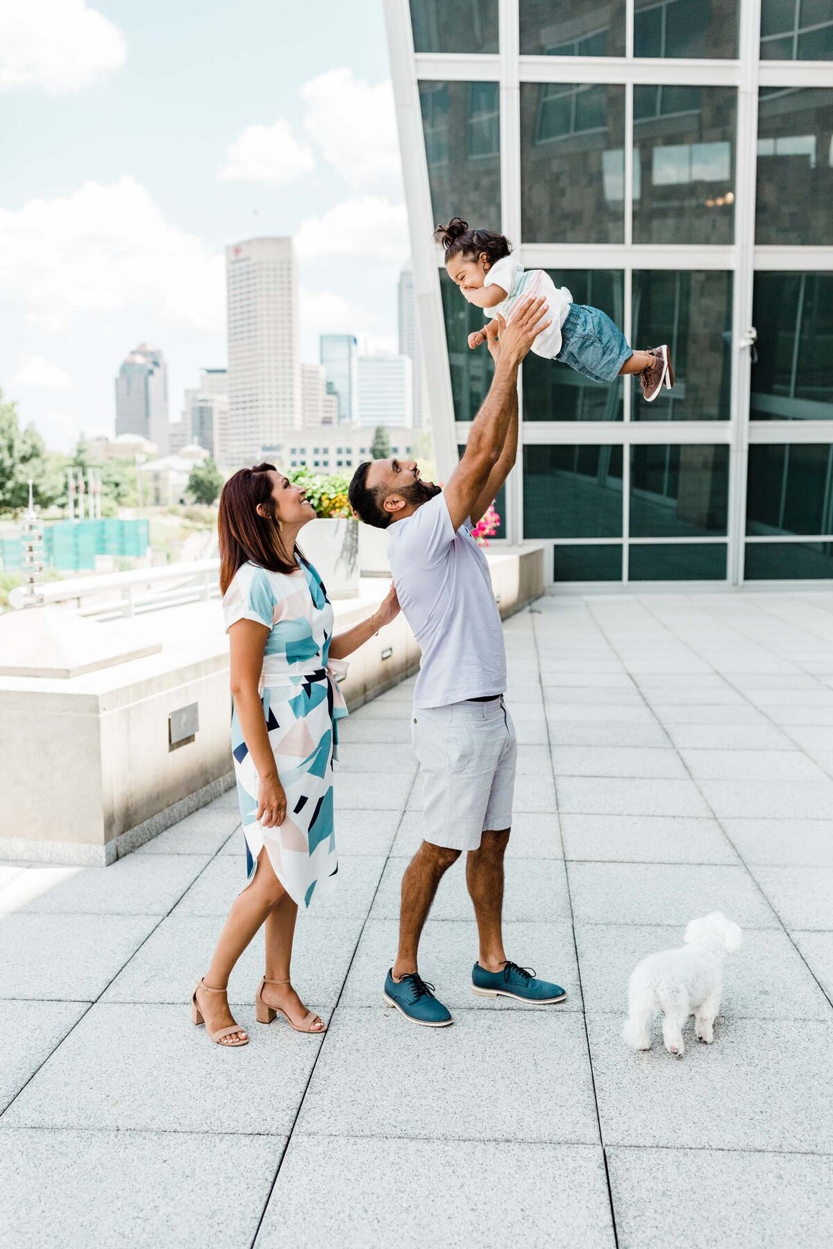Parents walking with their children near a modern building in downtown South Bend.