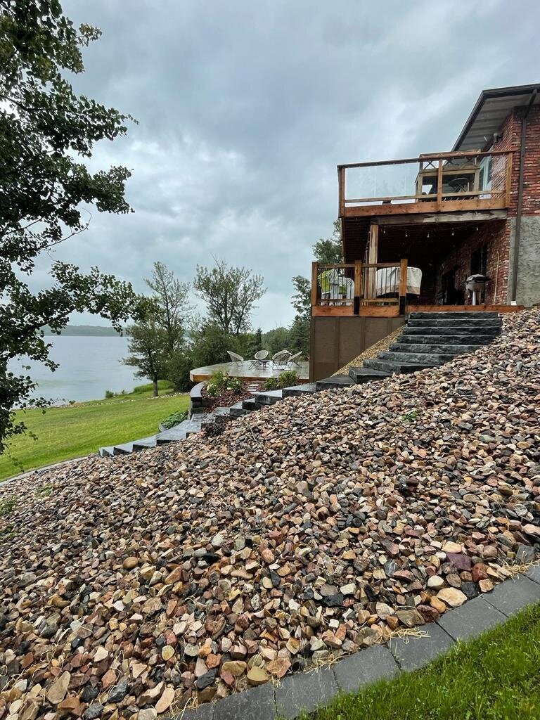 Lakehouse with big retaining wall 3 level deck plus natural concrete steps leading to a boat dock