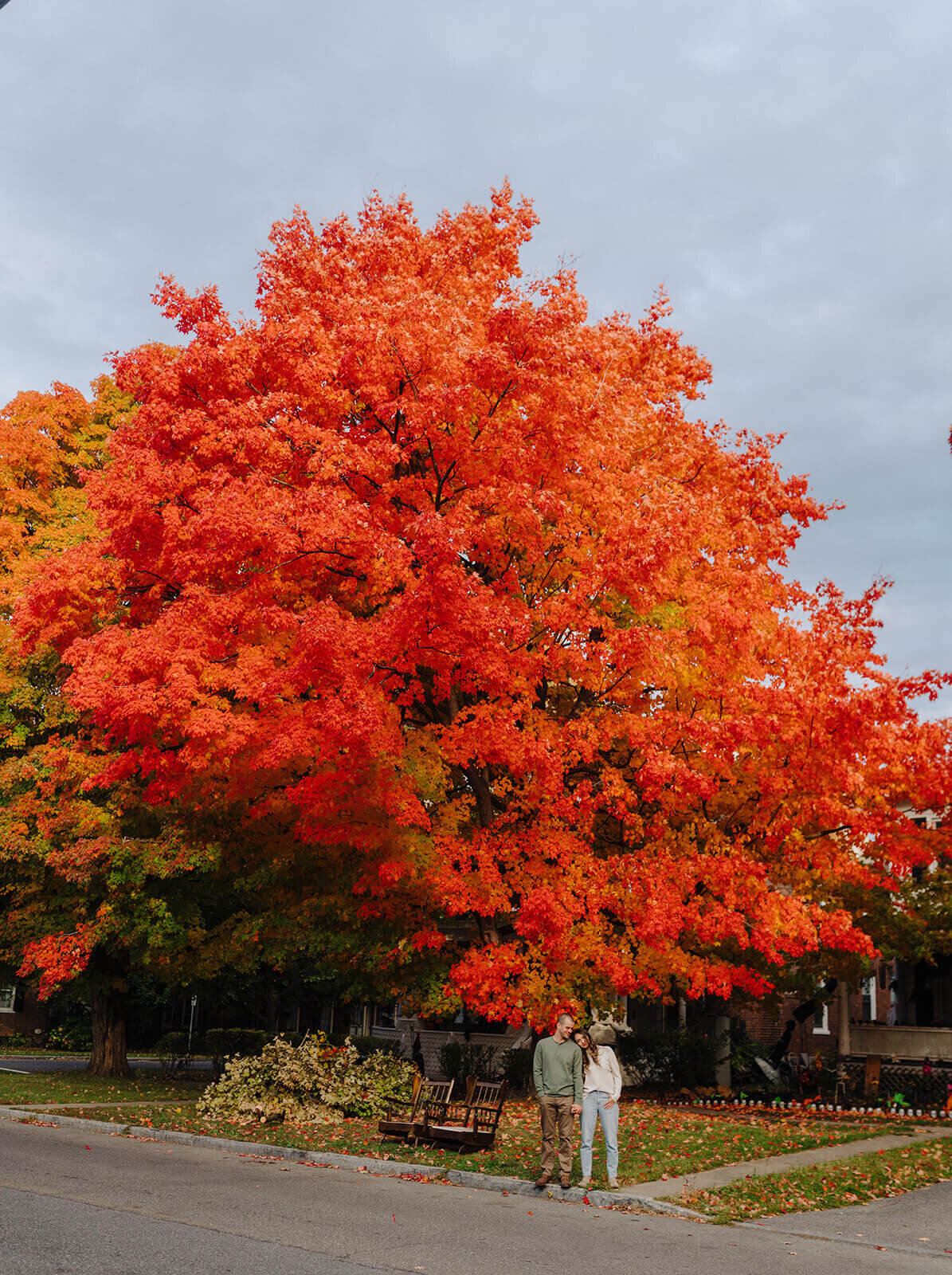 Couple standing in front of tree with red leaves at Finger Lakes Engagement session