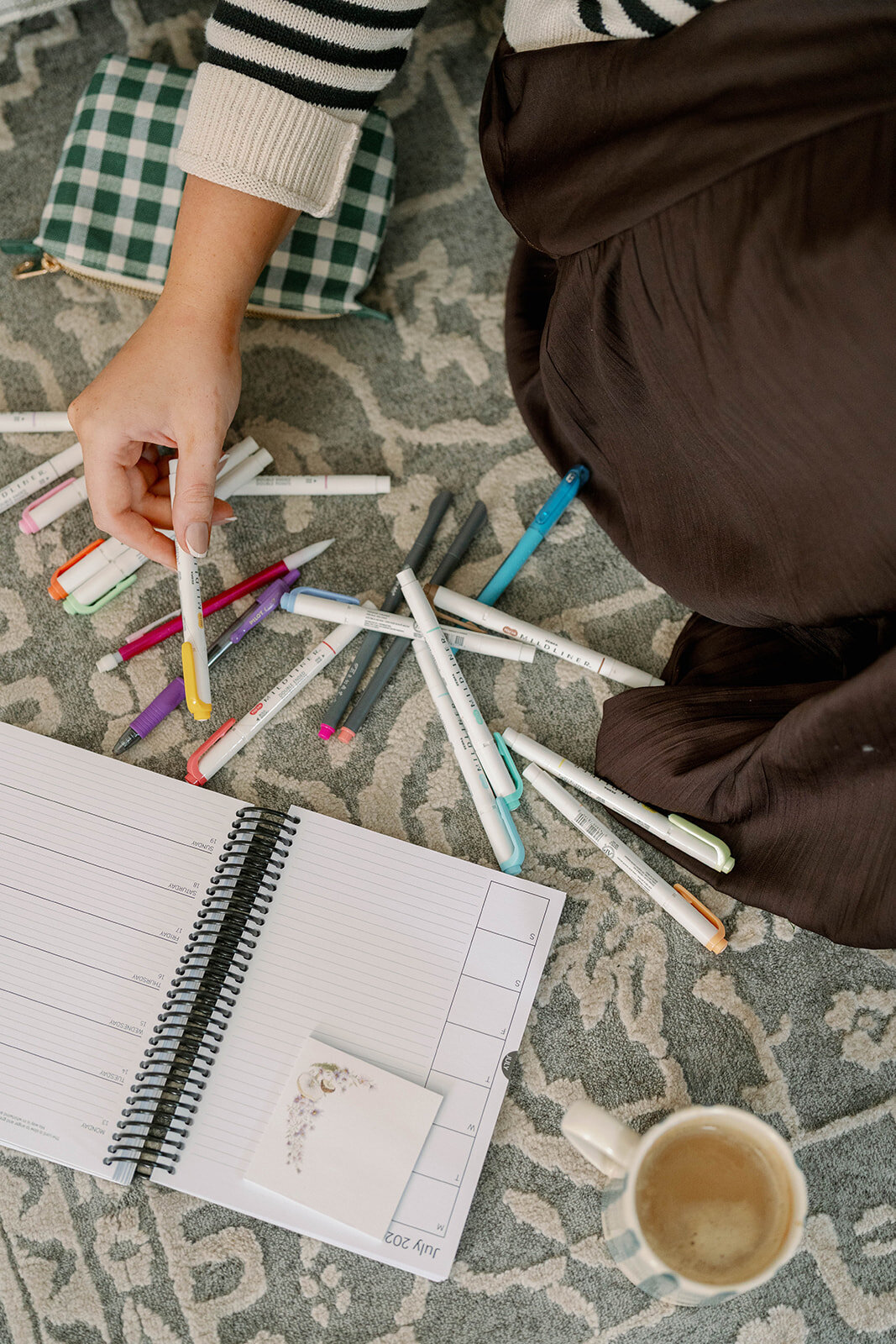 Overhead image of colorful pens, planner pages, and stationery on the floor during a branding session in Indiana.