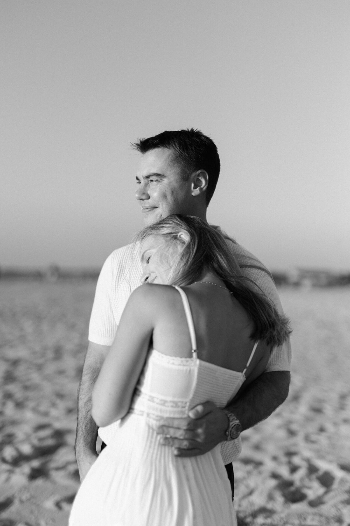 black and white portrait of a couple looking to the side at sunset beach