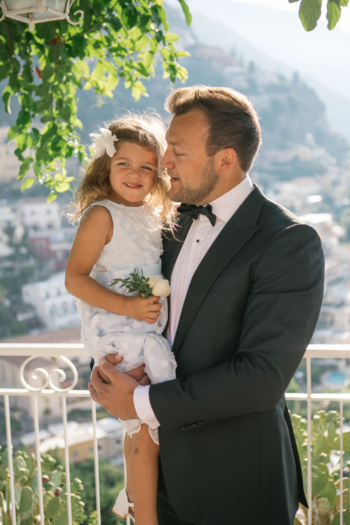 Bride and groom kissing while holding 'Eloped in Positano' sign – stylish destination wedding moment by Studio Rose