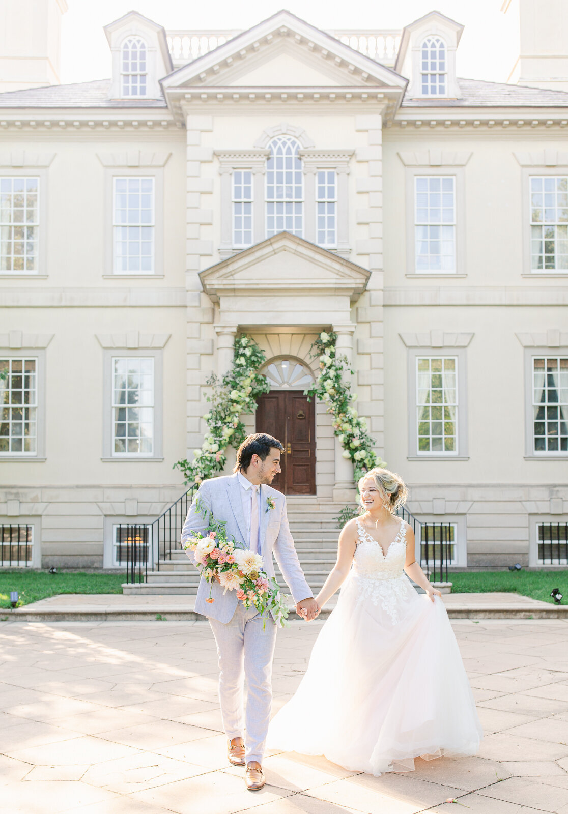 Bride and Groom walking in front of Great Marsh Estate at their summer wedding. Captured by Bethany Aubre Photography.