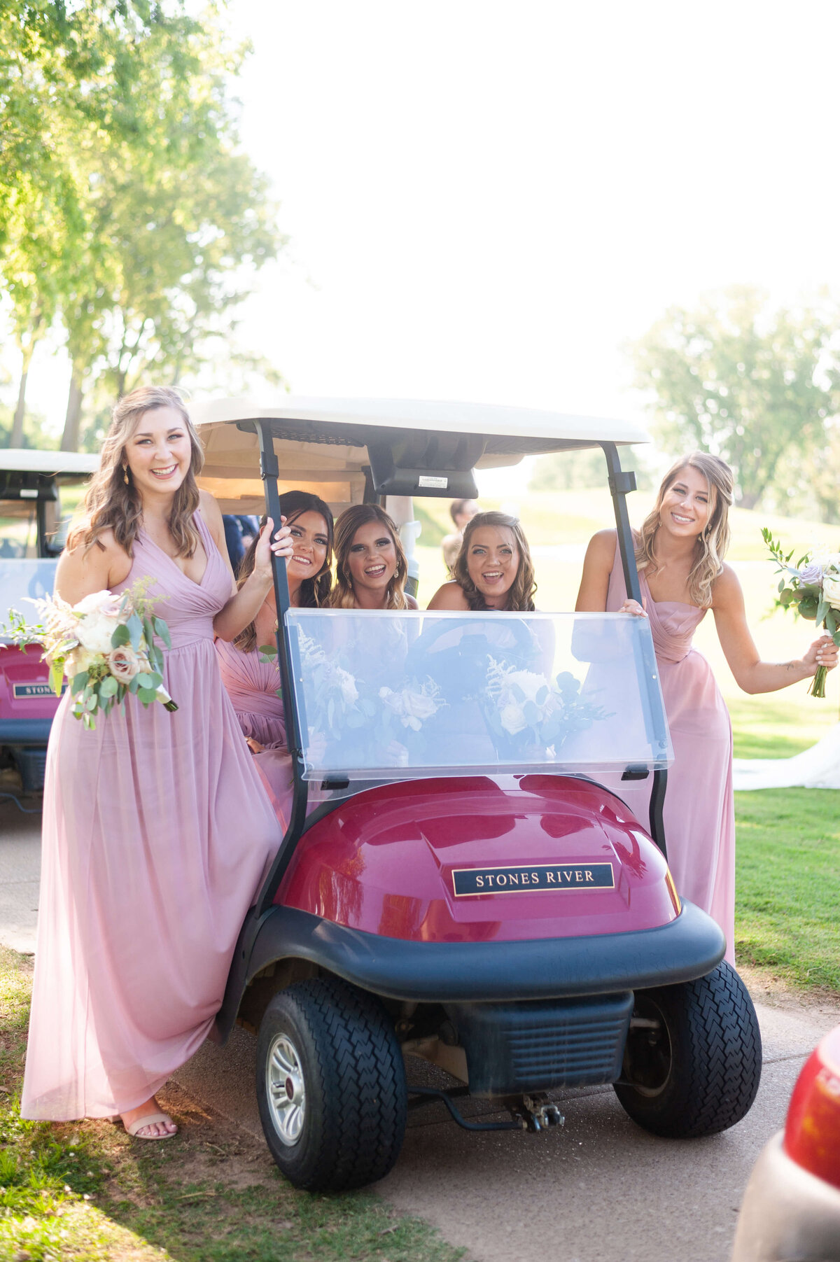 Bride with bridesmaids on a red golf cart