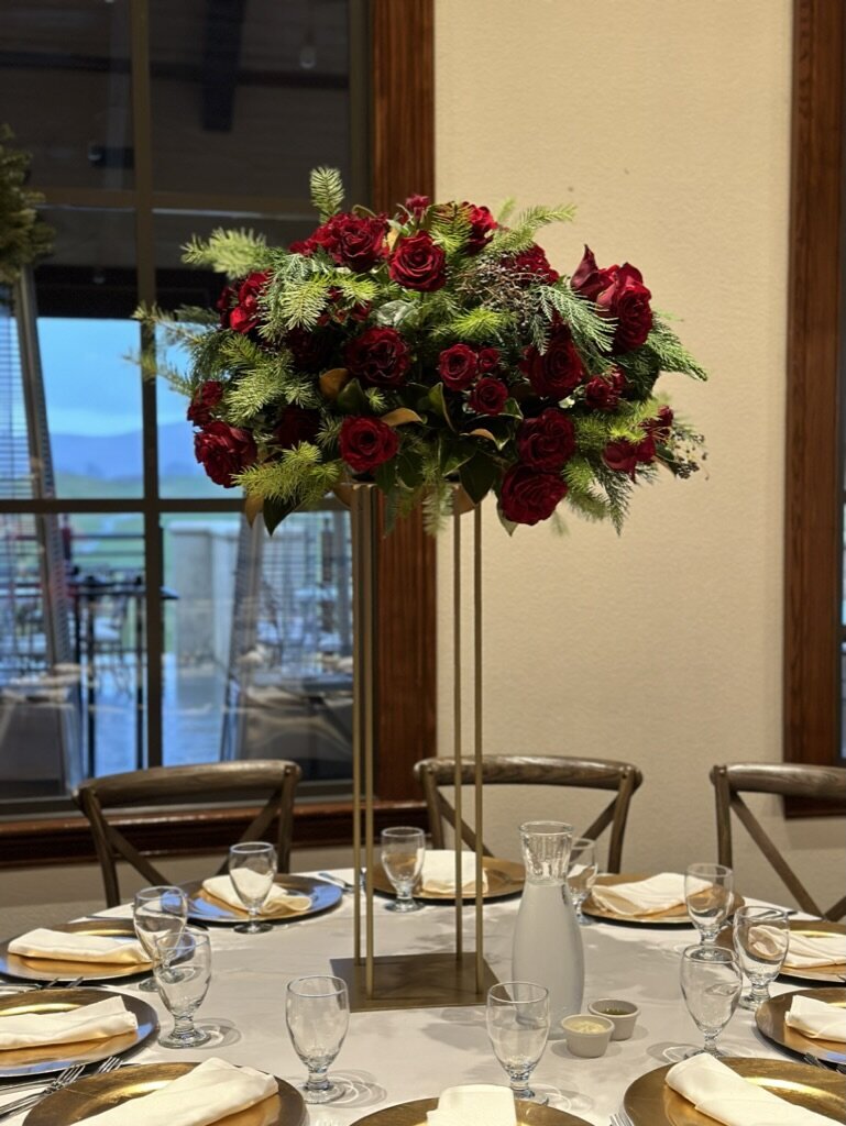gold accents, magnolia greens, red flower. tall arrangement 