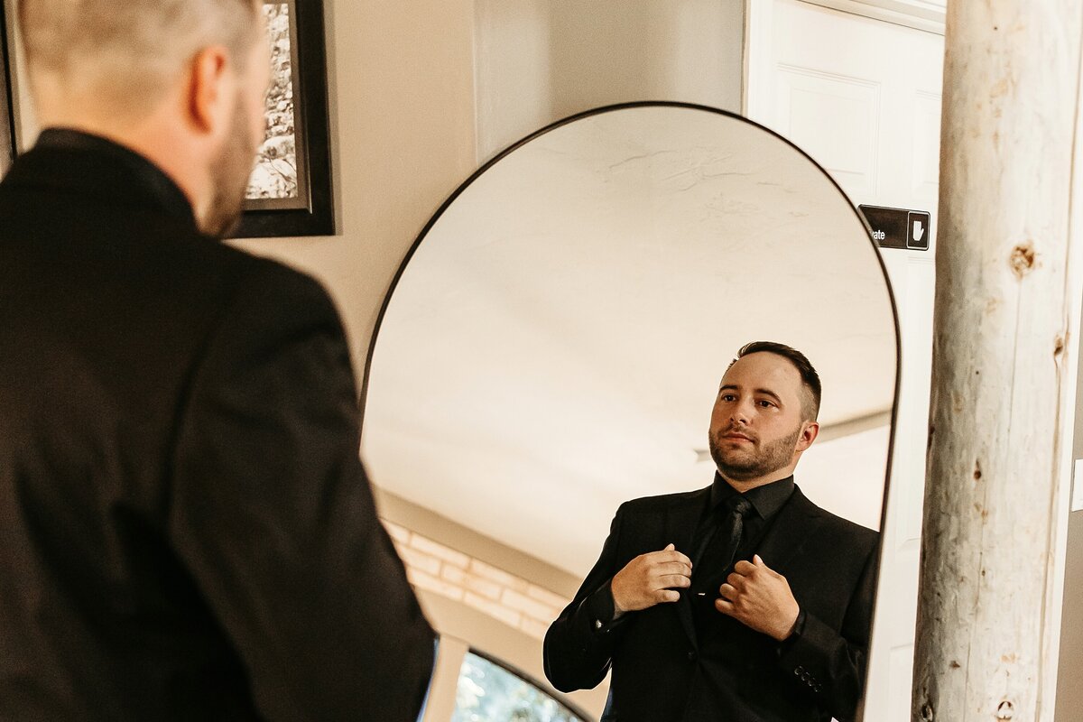 A boy showing off a black prom suit