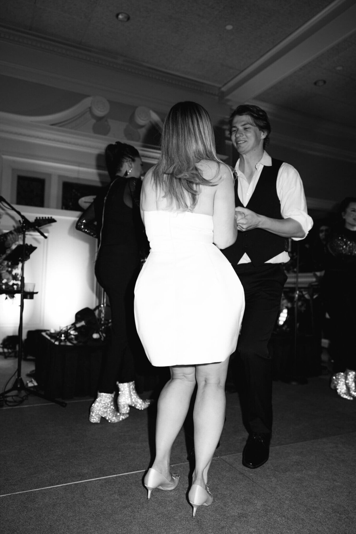 A black and white wedding photo of the bride and groom dancing during the wedding reception