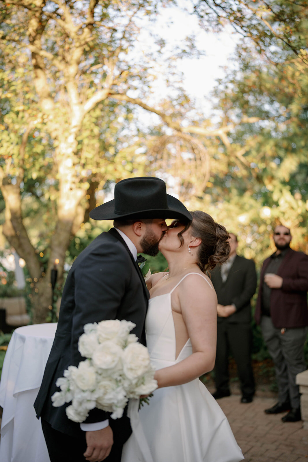Groom kissing bride during golden hour portraits at Café Cortina in Michigan.