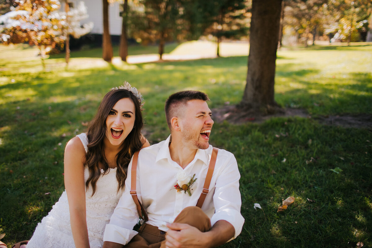 A bride and groom laugh together on their wedding day