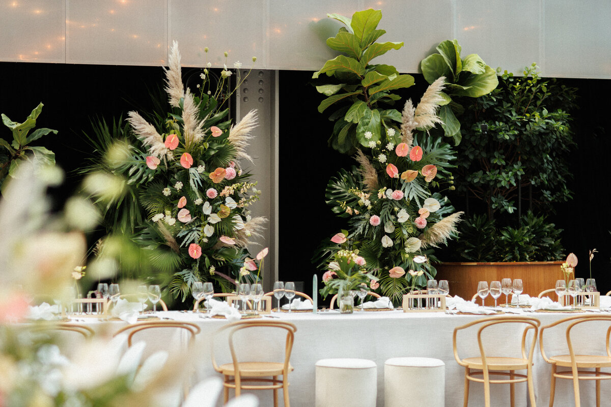 A table at a Cathcart wedding reception is decorated with pillars of exotic flowers.