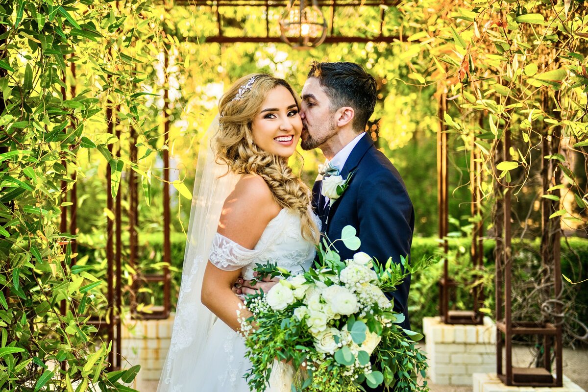 Bride and Groom kissing greenery lush at Stonebridge Manor Wedgewood Weddings