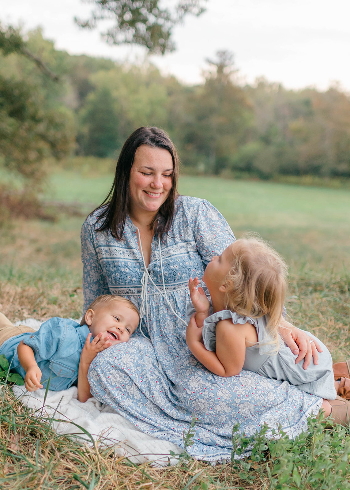 Mom playing with kids on the grass