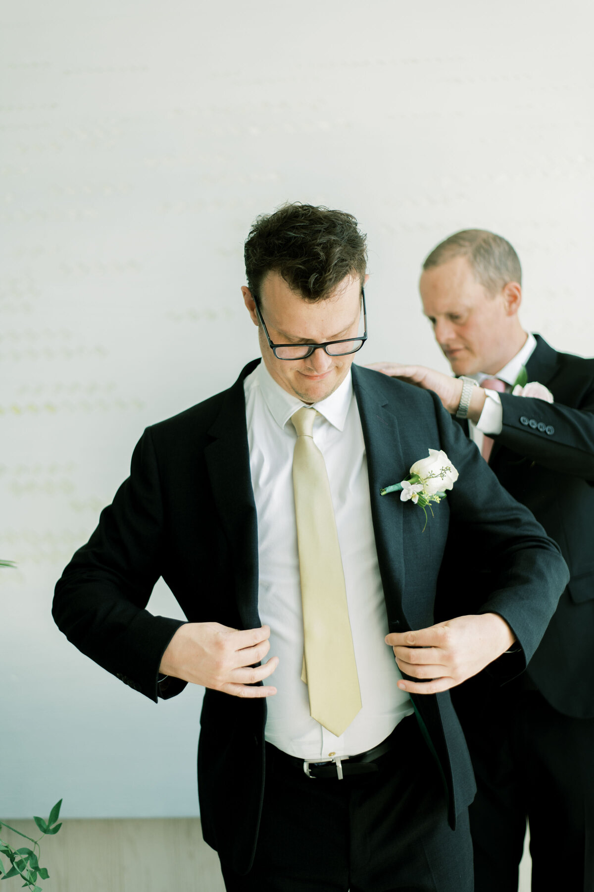 Groomsman helps groom get ready for the day at the pearle hotel