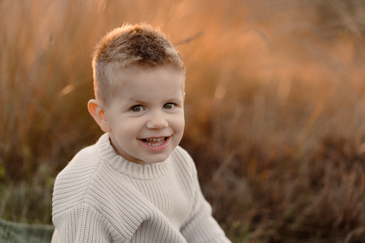 Portret van jongentje tijdens een gezinsshoot met zonsondergang