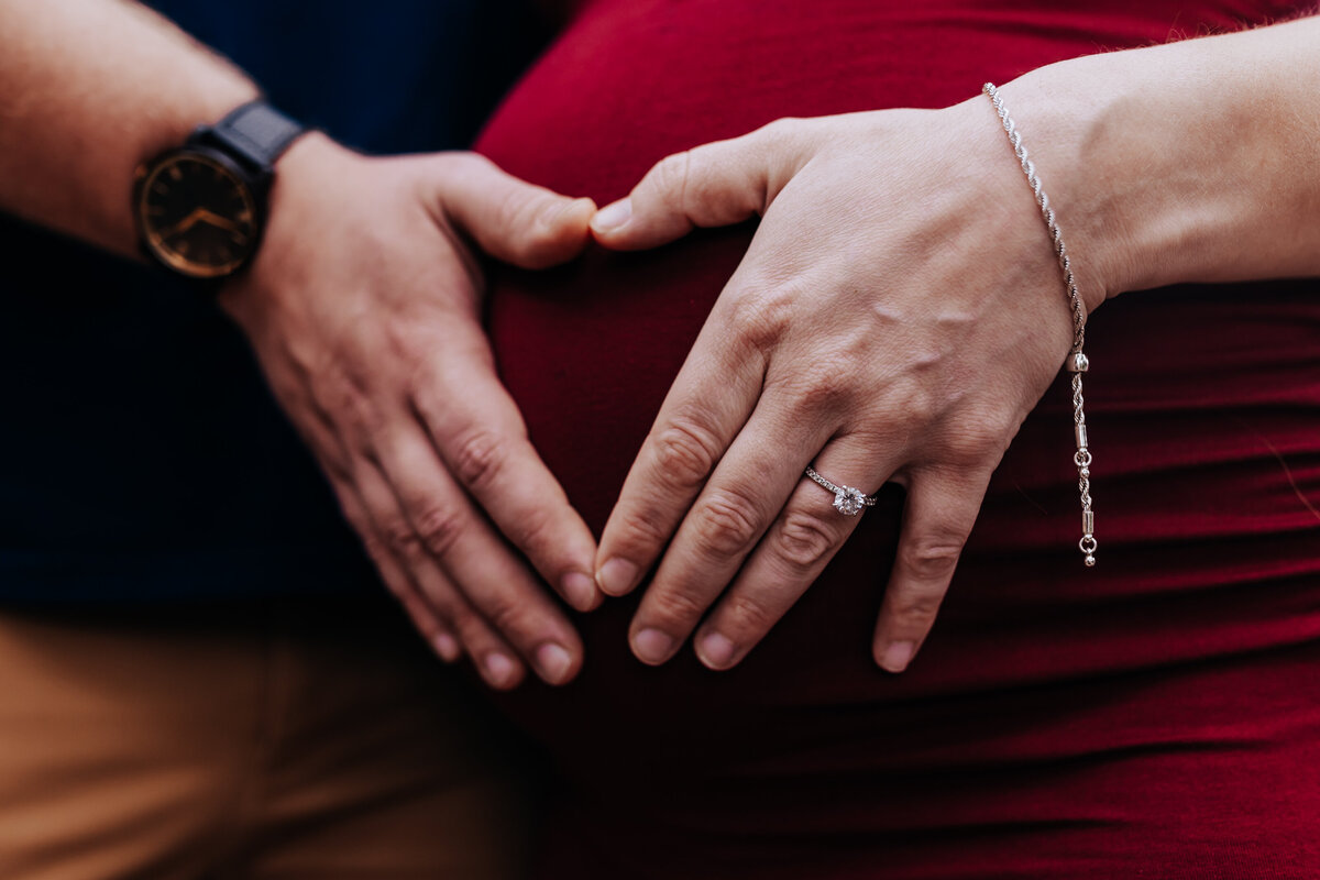 Nashville newborn photographer captures couple making heart on belly