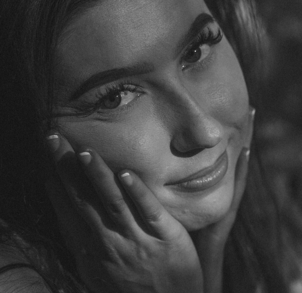 woman looks softly into the camera with her face in her hands during a photoshoot in Oregon