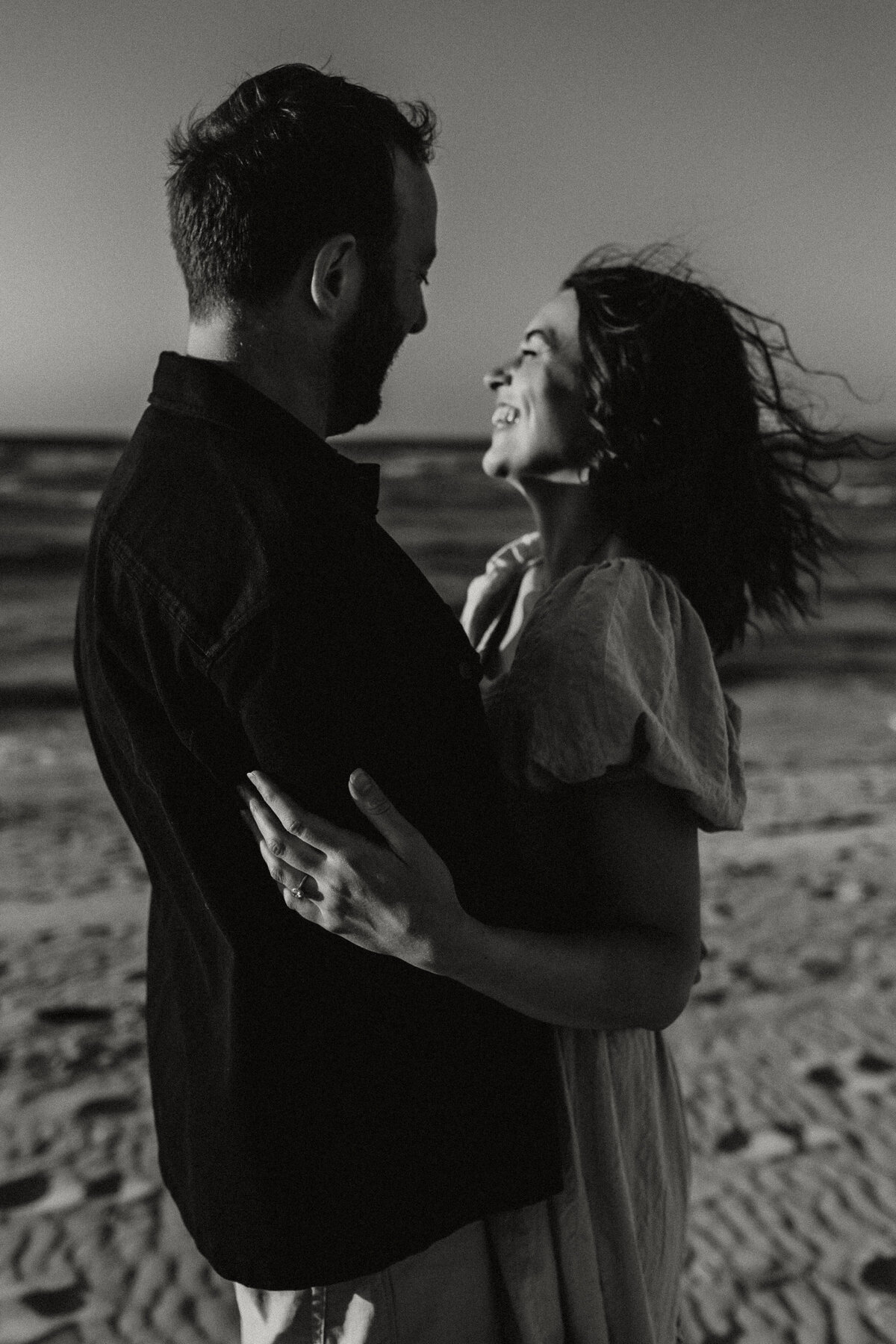  black and white Photograph of a young  engaged couple at the beach in West Cornwall on a sunny day