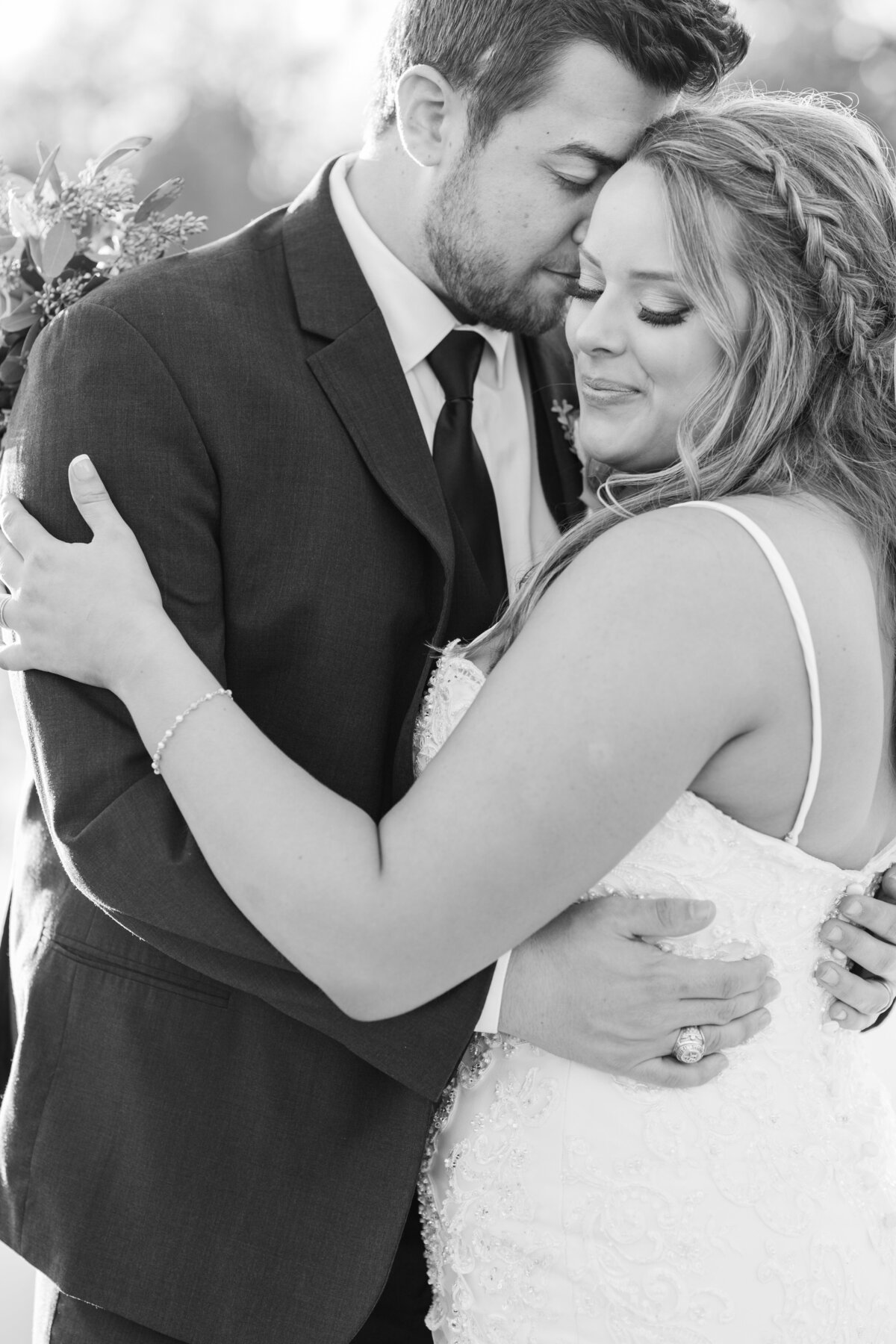 Black and white of Groom nuzzling bride and smiling after the ceremony at Peach Creek Ranch