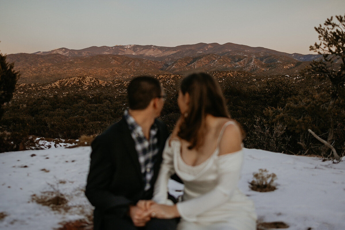 bride and groom with the Santa Fe mountains behind them