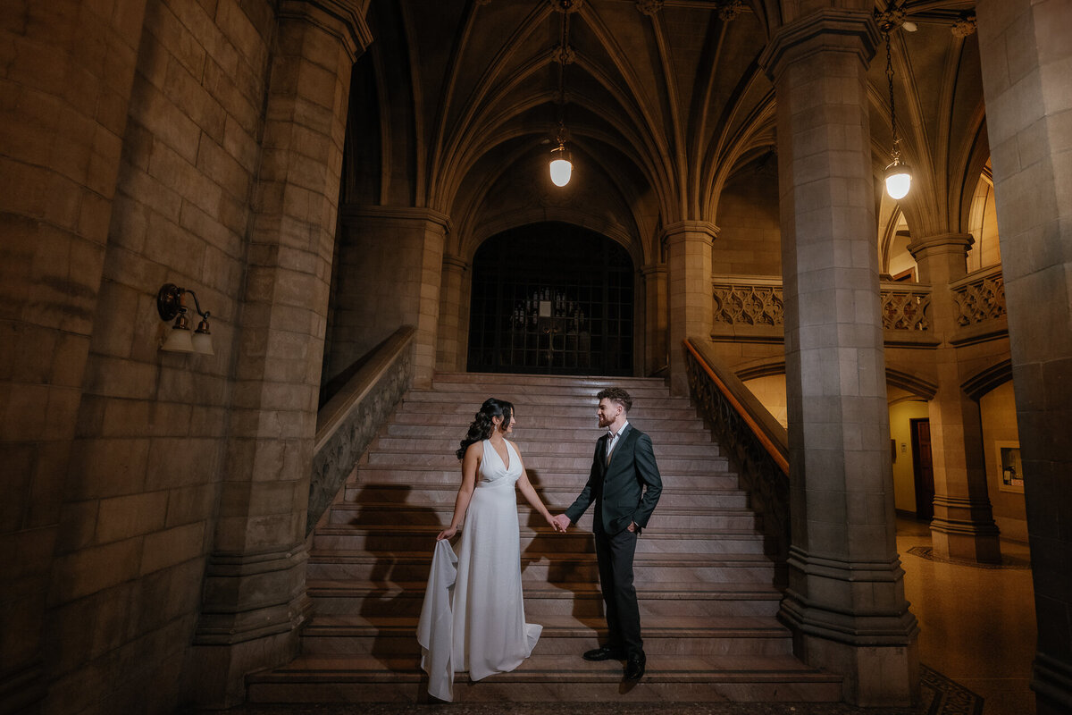 Engagement photo shot at Knox College Toronto, Ontario. the couple is holding hands looking at each other