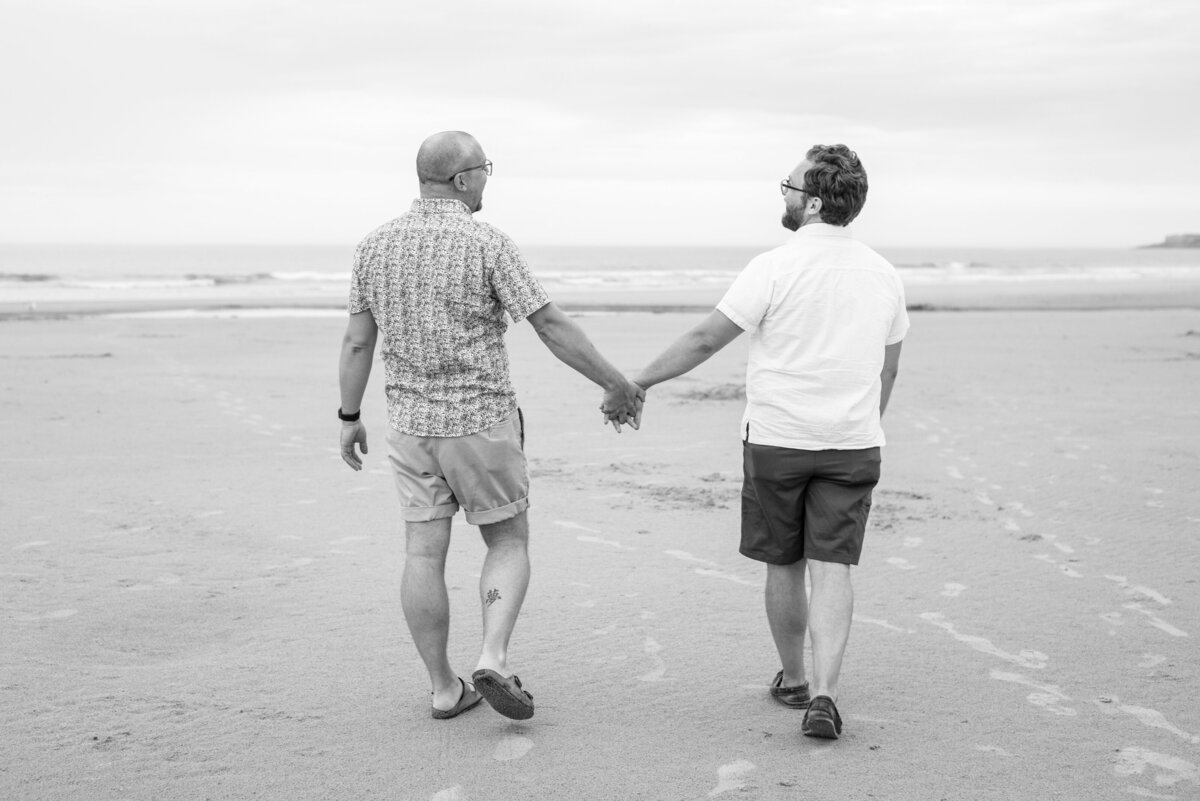 Two men holding hands on the beach in Ogunquit Maine