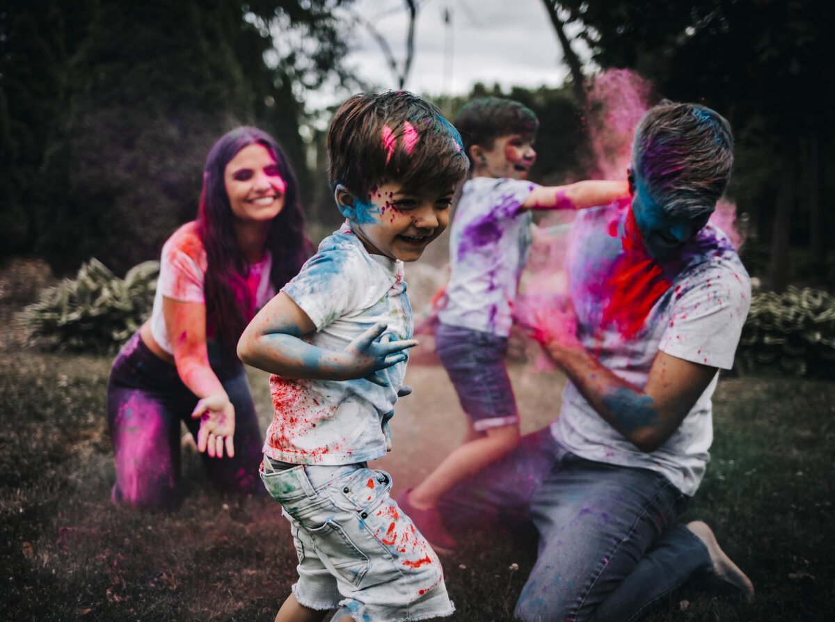 family of four playing with color bombs  for family photos