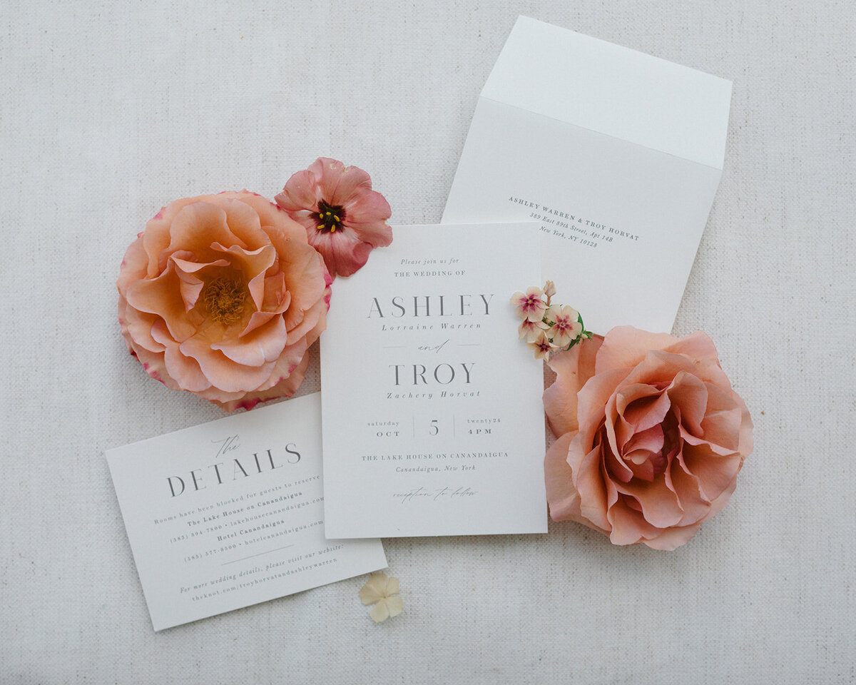 The invitation suite and floral flat lay at The Lake House on Canandaigua
