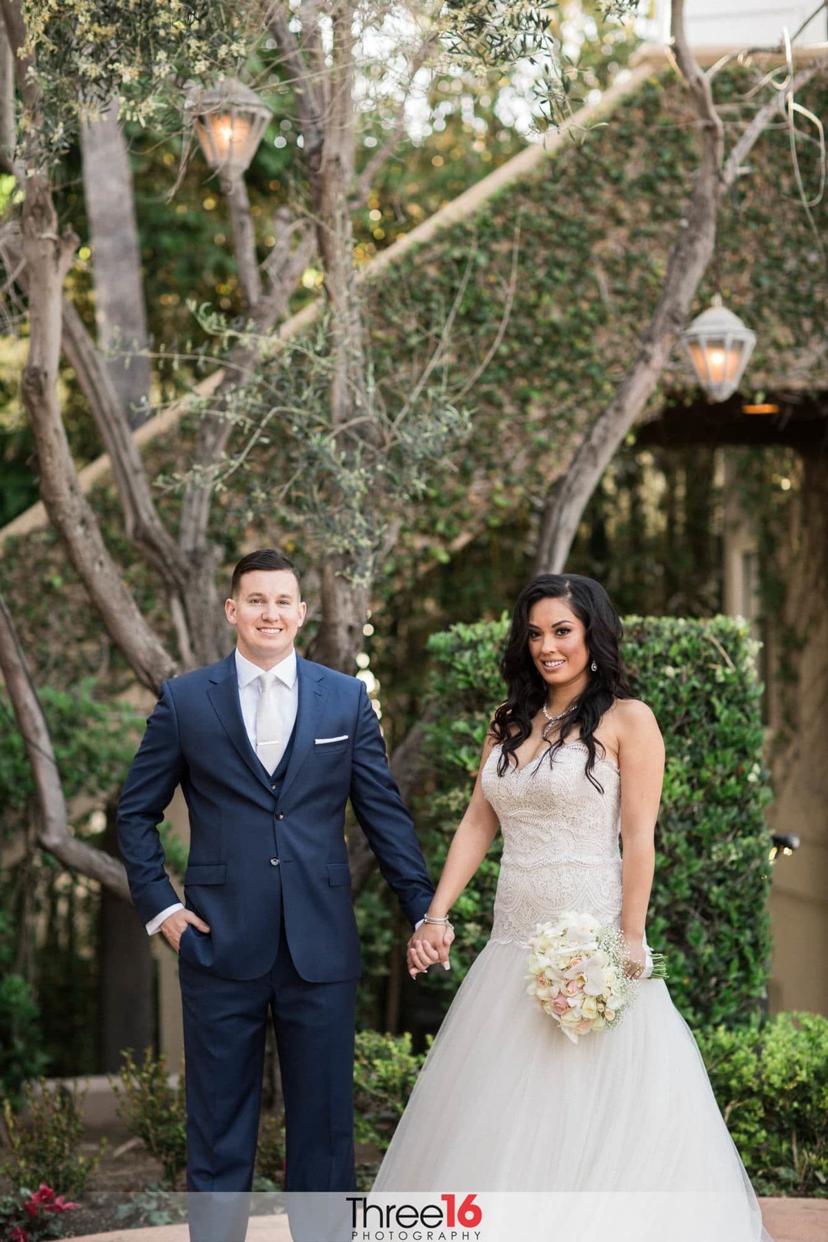 Bride and Groom are all smiles as they hold hands and pose for the wedding phtographer