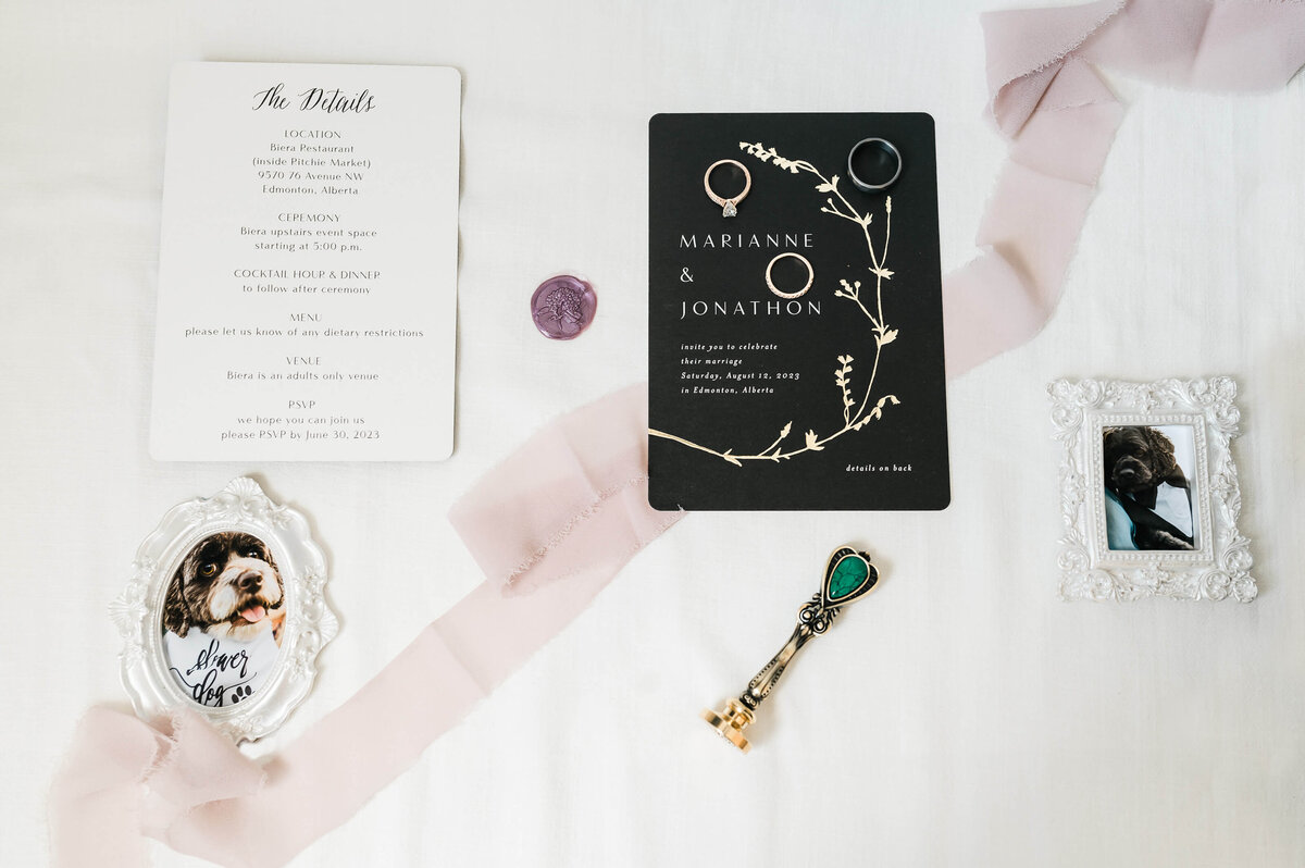 A fine art editorial flat lay of a small Edmonton wedding that includes framed photographs of the couple's dogs