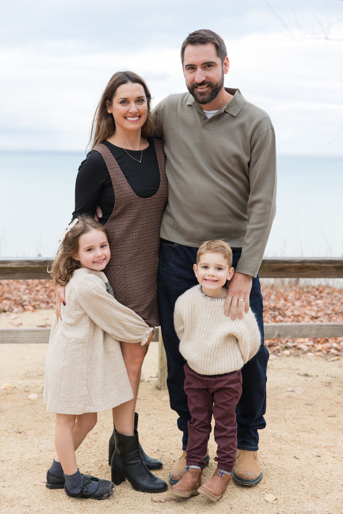 A family of four embracing and smiling