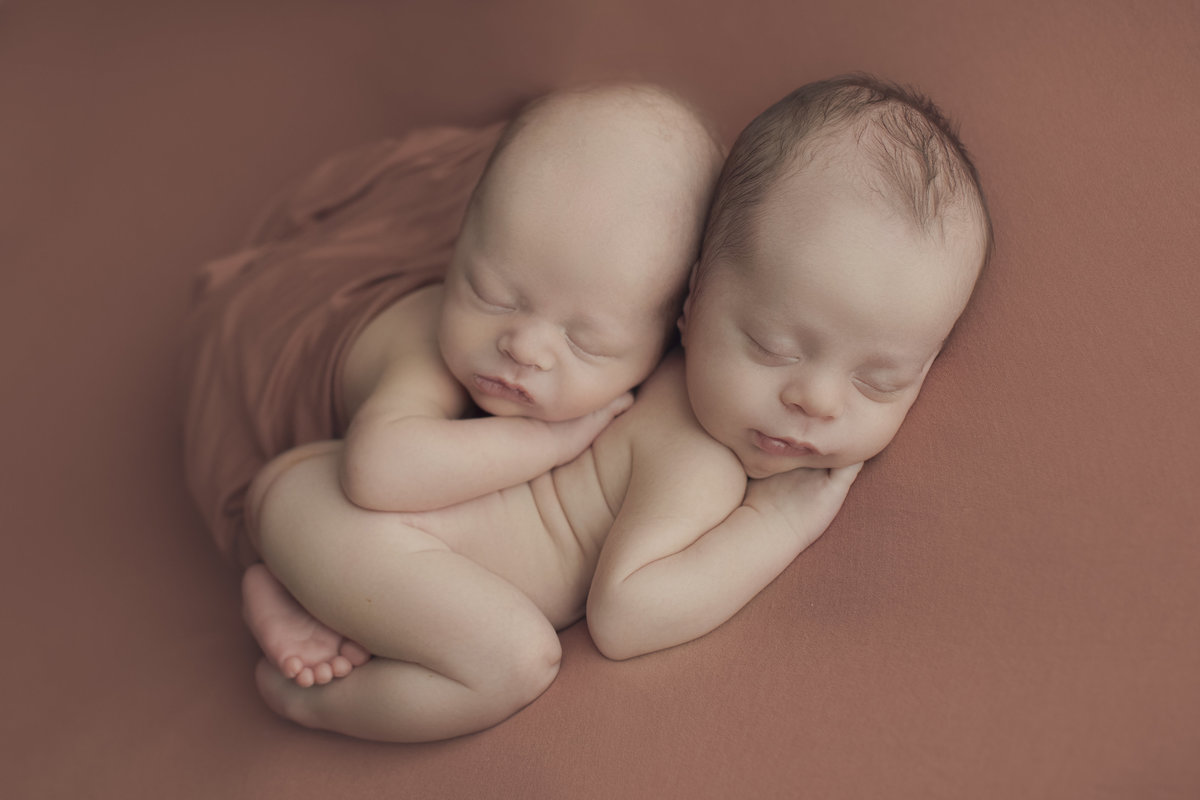 twins snuggle and sleep for first photoshoot in Denver colorado Photography studio