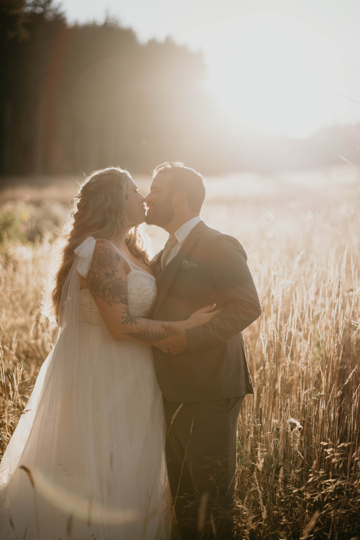 Bride and groom about to kiss at golden hour in a field after wedding