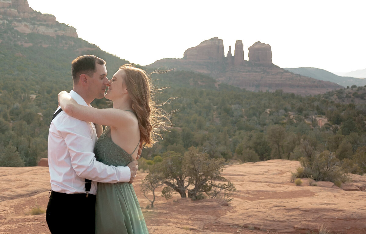 Couple standing against red rock backdrop during Sedona engagement session