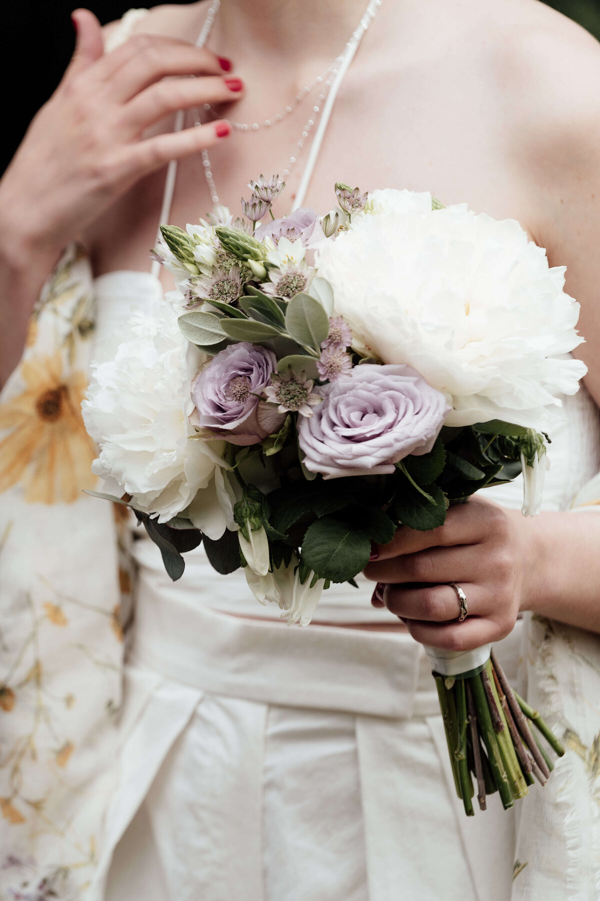 A bride holds her bouquet of summer flowers 